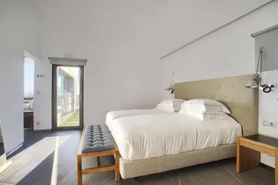 a bedroom with a large white bed and a window at Retiros Los Agustinos in Arcos de la Frontera