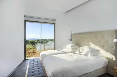 two beds in a room with a large window at Retiros Los Agustinos in Arcos de la Frontera