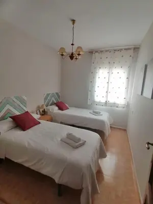 a bedroom with two beds and a window at Keka en Playa la Victoria con Ascensor Grupo AC Gestion in Cádiz