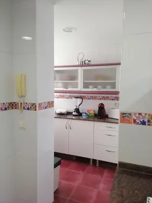a kitchen with white cabinets and a red floor at Keka en Playa la Victoria con Ascensor Grupo AC Gestion in Cádiz