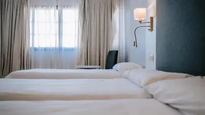 a row of beds in a hotel room with a window at Hotel Bahia Sur in San Fernando