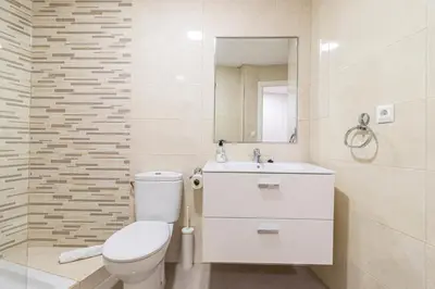 a bathroom with a toilet and a sink and a mirror at Allo Apartments Consistorio Centro 2 Habitaciones in Jerez de la Frontera