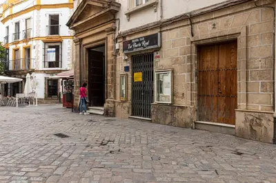 a woman walking down a street next to a building at Allo Apartments Consistorio Centro 2 Habitaciones in Jerez de la Frontera