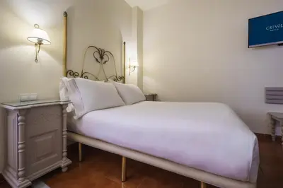 a bedroom with a white bed and a table at Crisol Chiclana in Chiclana de la Frontera