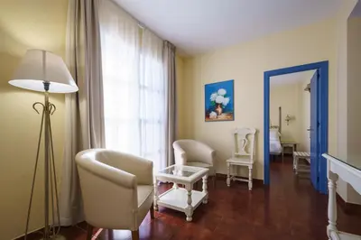 a living room with chairs and a table and a lamp at Crisol Chiclana in Chiclana de la Frontera