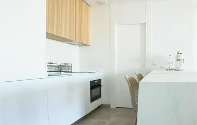 a white kitchen with a counter and a sink at Gorgeous Apartment In Chipiona in Chipiona