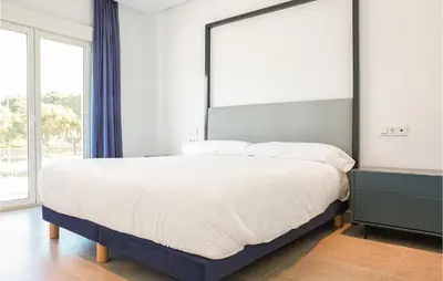 a bedroom with a large bed with a large mirror at Gorgeous Apartment In Chipiona in Chipiona