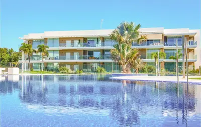 a hotel with a swimming pool in front of a building at Gorgeous Apartment In Chipiona in Chipiona