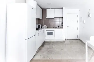 a white kitchen with white cabinets and appliances at Apartamento San Juan in El Puerto de Santa María