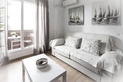 a white living room with a couch and a table at Apartamento San Juan in El Puerto de Santa María