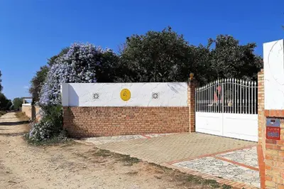 a brick fence with a white gate and a white door at Finca La Parrilla Maison Piscine nature chevaux in Arcos de la Frontera