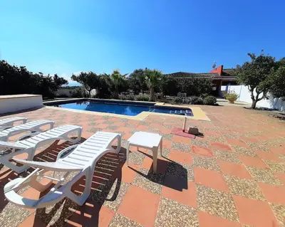 a group of lounge chairs and a swimming pool at Finca La Parrilla Maison Piscine nature chevaux in Arcos de la Frontera