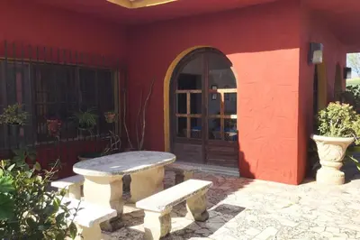 a stone bench sitting outside of a house with a door at Finca La Parrilla Maison Piscine nature chevaux in Arcos de la Frontera