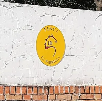 a yellow sign on the side of a brick wall at Finca La Parrilla Maison Piscine nature chevaux in Arcos de la Frontera