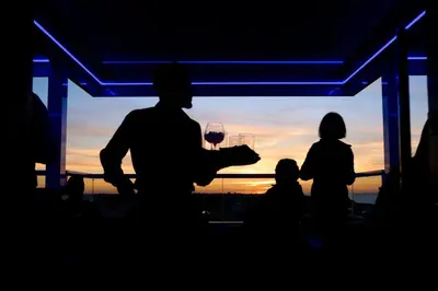 a man holding a glass of wine at sunset at Hotel Guadalquivir in Sanlúcar de Barrameda