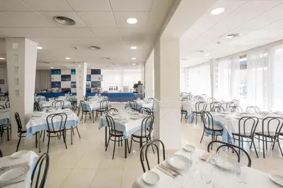 a dining room with white tables and chairs at Hotel Guadalquivir in Sanlúcar de Barrameda