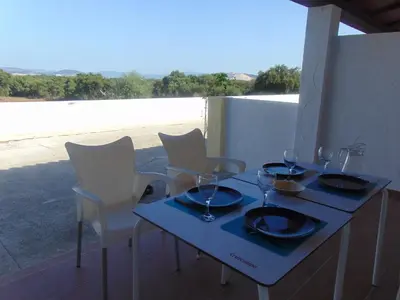 a blue table with chairs and wine glasses on it at Studio andalou , campagne , chevaux , piscine commune in Arcos de la Frontera