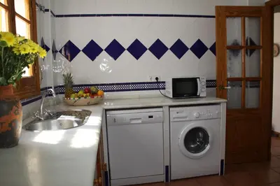 a kitchen with a washing machine and a sink at Penthouse Sleeps 4 with Private Garden in Chipiona