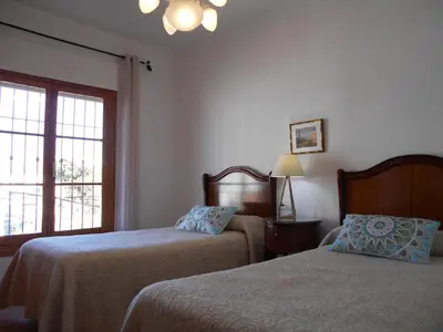 a bedroom with two beds and a window at Penthouse Sleeps 4 with Private Garden in Chipiona