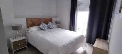 a bedroom with a white bed and a window at Guesting Hospital in Cádiz