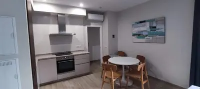 a small kitchen with a table and chairs in a room at Guesting Hospital in Cádiz