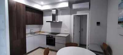 a kitchen with white cabinets and a white table at Guesting Hospital in Cádiz