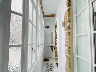 a hallway with white walls and large windows at innCádizCasa Señorial Rivadavia in Cádiz