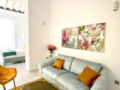 a living room with a couch and a painting on the wall at innCádizCasa Señorial Rivadavia in Cádiz