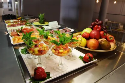 a buffet with several plates of fruit and wine glasses at Hotel Agaró in Chipiona