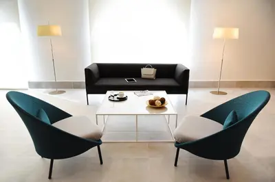a living room with two chairs and a coffee table at Hotel Agaró in Chipiona