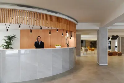a man standing behind a counter in a lobby at Hotel Agaró in Chipiona