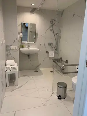a white bathroom with a sink and a toilet at Hotel Agaró in Chipiona