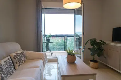 a living room with a couch and a table and a large window at R&B Vistahermosa Views in El Puerto de Santa María