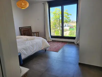 a bedroom with a bed and a large window at Family house with nice garden 10min from Sanlúcar in Sanlúcar de Barrameda
