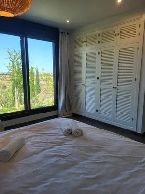 a bedroom with a large bed with two towels on it at Family house with nice garden 10min from Sanlúcar in Sanlúcar de Barrameda