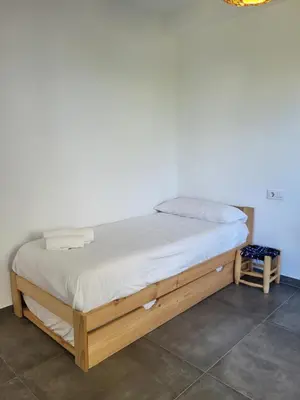 a bed in a room with a white wall at Family house with nice garden 10min from Sanlúcar in Sanlúcar de Barrameda