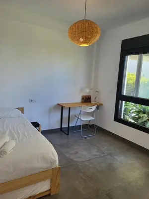 a bedroom with a bed and a table and a window at Family house with nice garden 10min from Sanlúcar in Sanlúcar de Barrameda