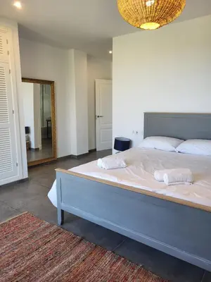 a bedroom with a large bed with two towels on it at Family house with nice garden 10min from Sanlúcar in Sanlúcar de Barrameda