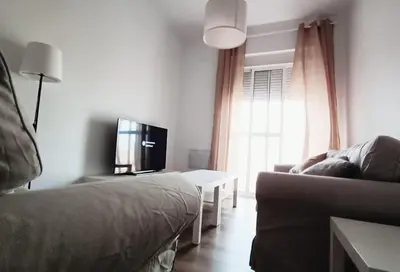 a living room with a couch and a tv and a table at Apartamento Victoria in Cádiz