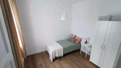 a small bedroom with a bed and a white cabinet at Apartamento Victoria in Cádiz