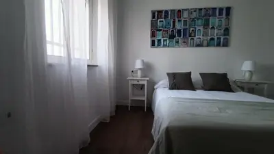 a bedroom with two beds and a picture on the wall at Apartamento Victoria in Cádiz