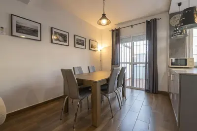 a kitchen and dining room with a wooden table and chairs at Duplex Near the Beach in Chiclana de la Frontera