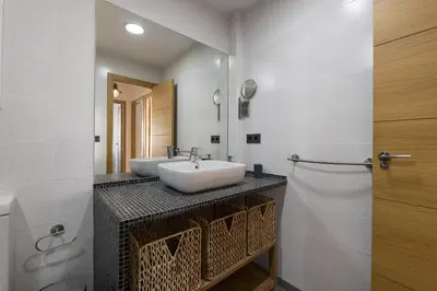 a bathroom with a white sink and a mirror at Duplex Near the Beach in Chiclana de la Frontera