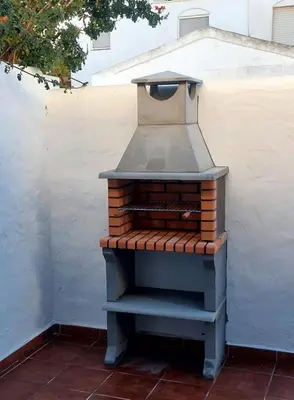 an outdoor oven sitting next to a white wall at Duplex Near the Beach in Chiclana de la Frontera