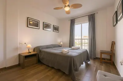 a bedroom with a bed and a window at Beautiful Duplex in Chiclana de la Frontera