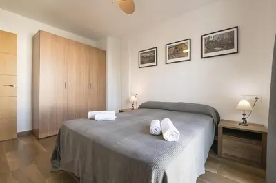 a bedroom with a bed with two towels on it at Beautiful Duplex in Chiclana de la Frontera