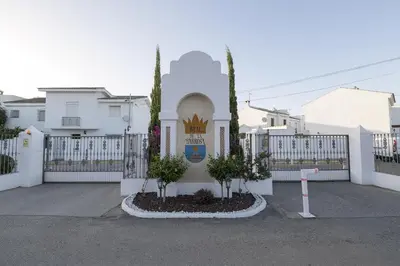 a white fence with a gate with trees in front of it at Beautiful Duplex in Chiclana de la Frontera