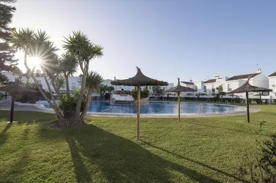 a park with umbrellas and a swimming pool at Beautiful Duplex in Chiclana de la Frontera