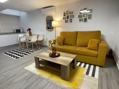 a living room with a couch and a table at Aromas de Bodega in Jerez de la Frontera