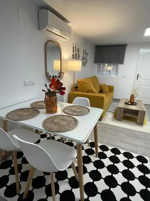 a dining room and living room with a table and chairs at Aromas de Bodega in Jerez de la Frontera